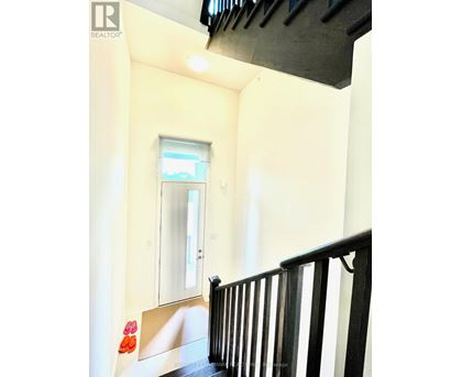 A hallway with a black railing and a window.