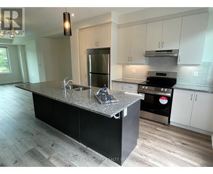 A kitchen with a granite countertop and stainless steel appliances.