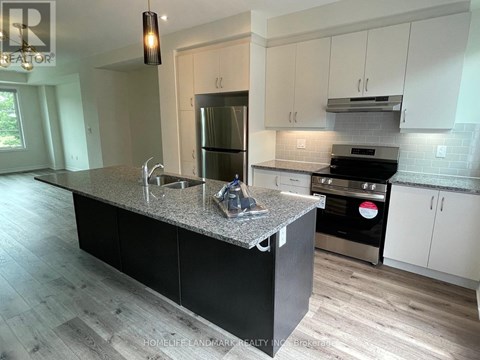 A kitchen with a granite countertop and stainless steel appliances.