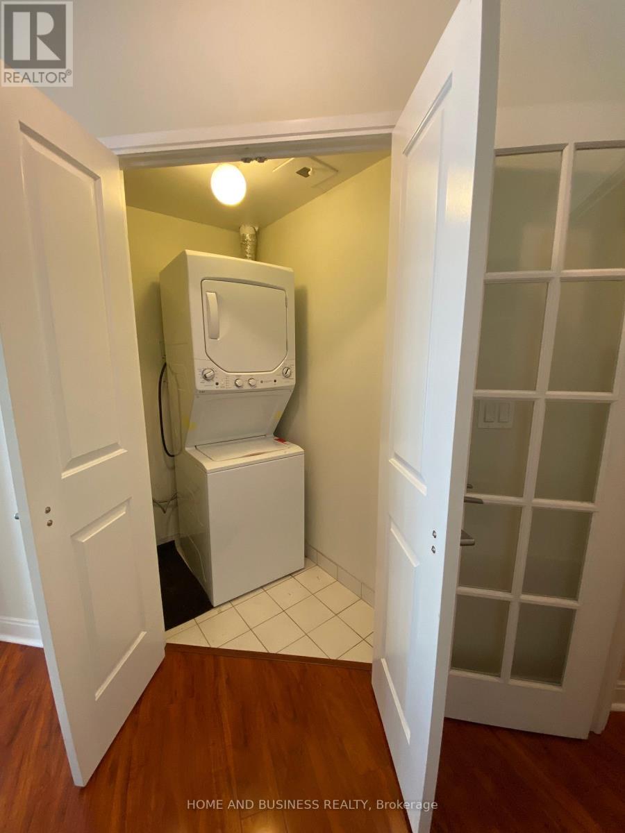 A white toilet is in a small room with a door open to a hallway.
