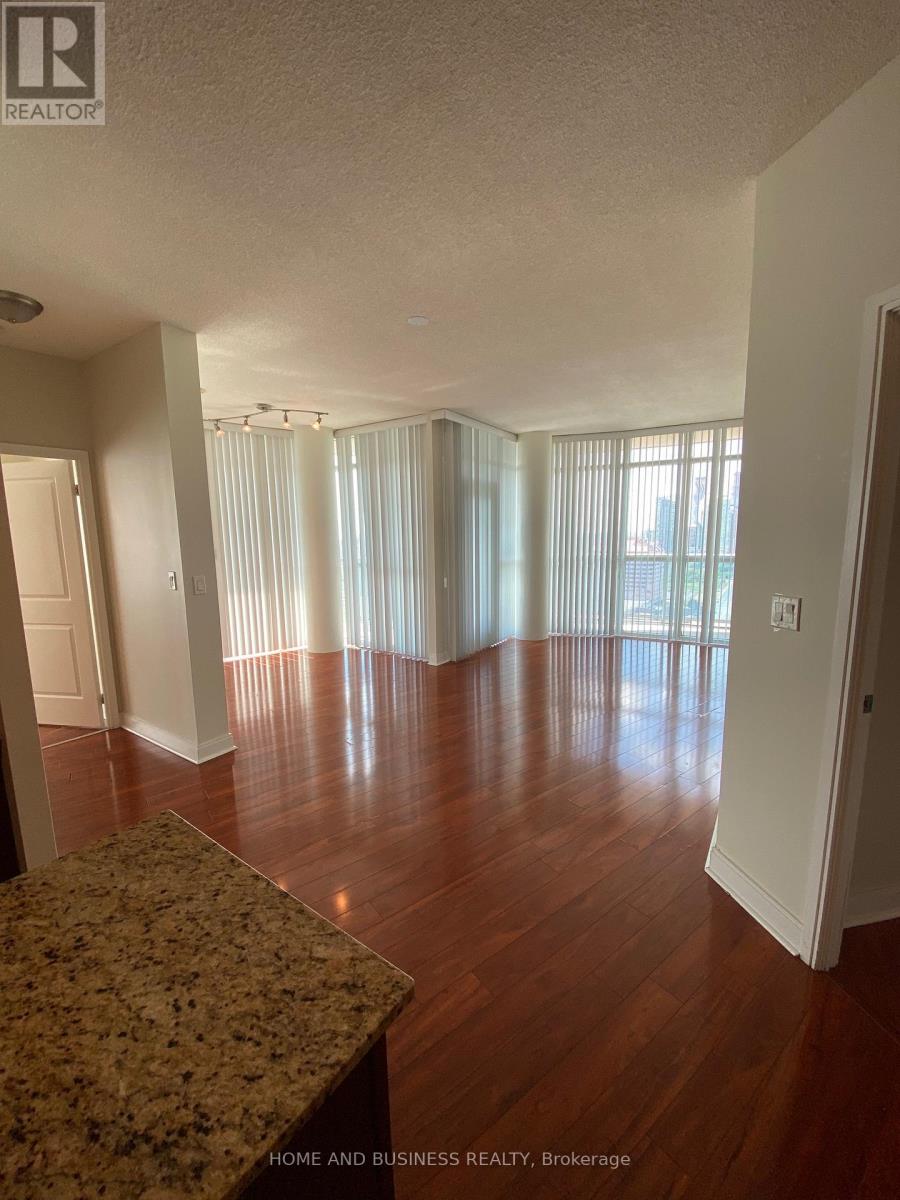 A large empty room with wooden floors and a marble countertop.