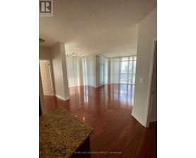 A large empty room with wooden floors and a marble countertop.