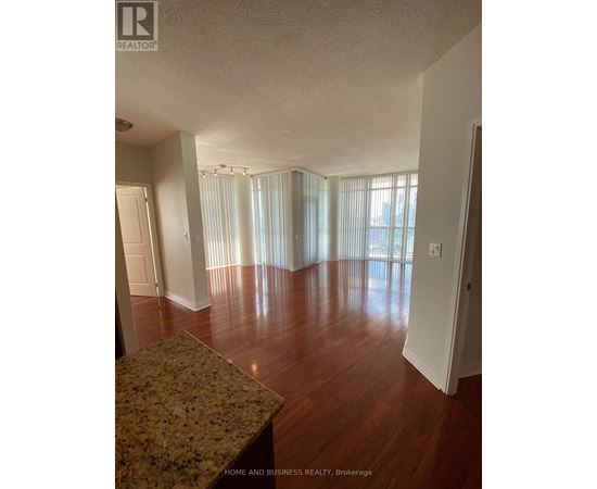 A large empty room with wooden floors and a marble countertop.