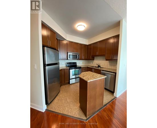 A kitchen with wooden cabinets and a refrigerator.
