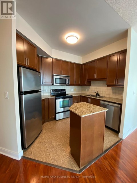 A kitchen with wooden cabinets and a refrigerator.