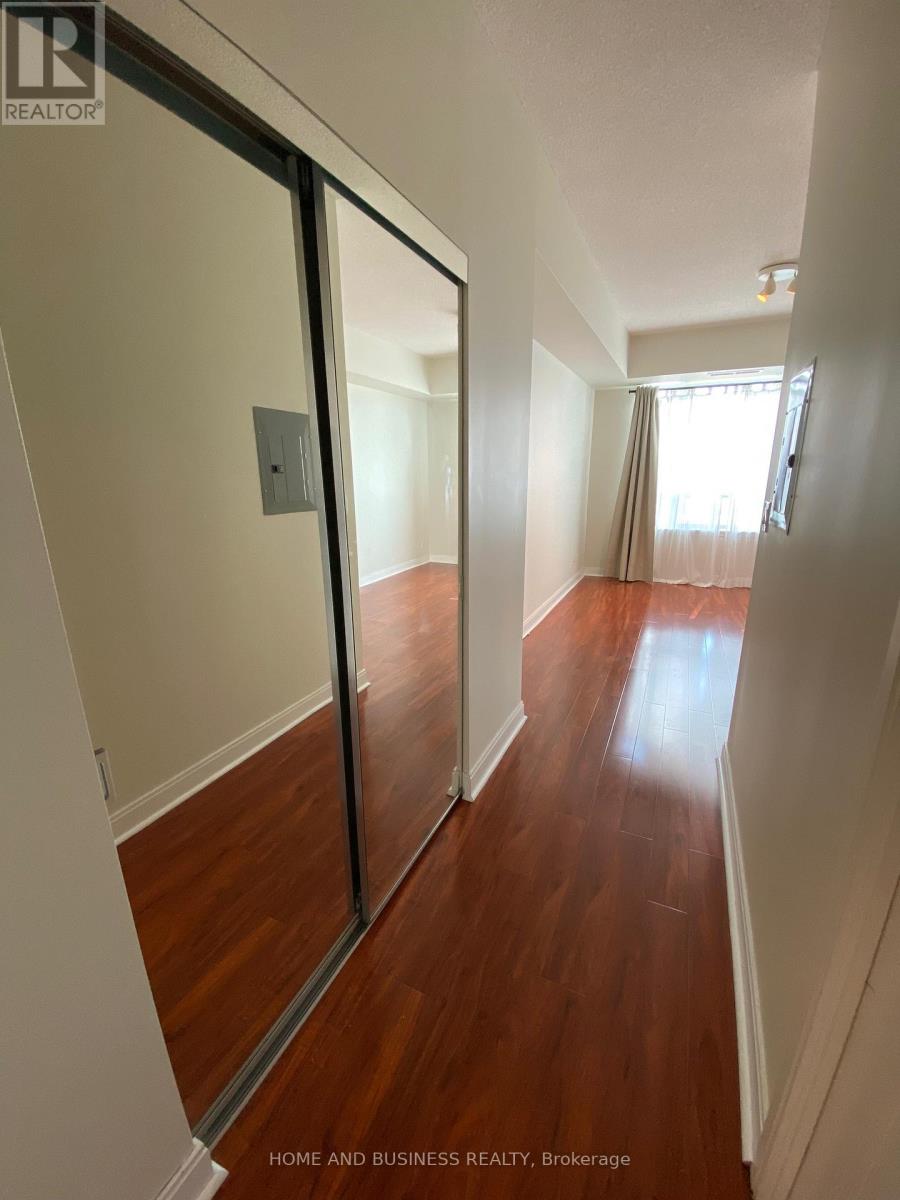 A hallway with wood floors and white walls.