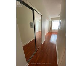 A hallway with wood floors and white walls.