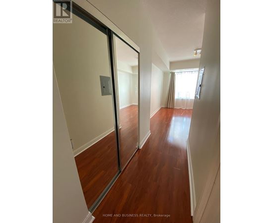 A hallway with wood floors and white walls.