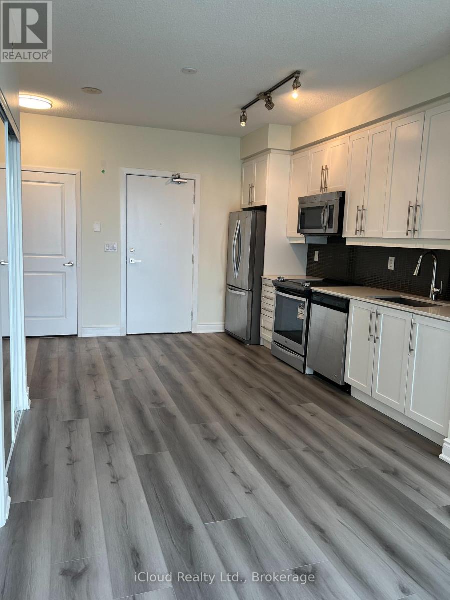 A kitchen with white cabinets and a black countertop.