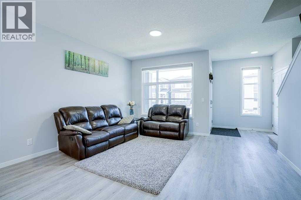 A living room with two brown leather sofas and a grey rug.
