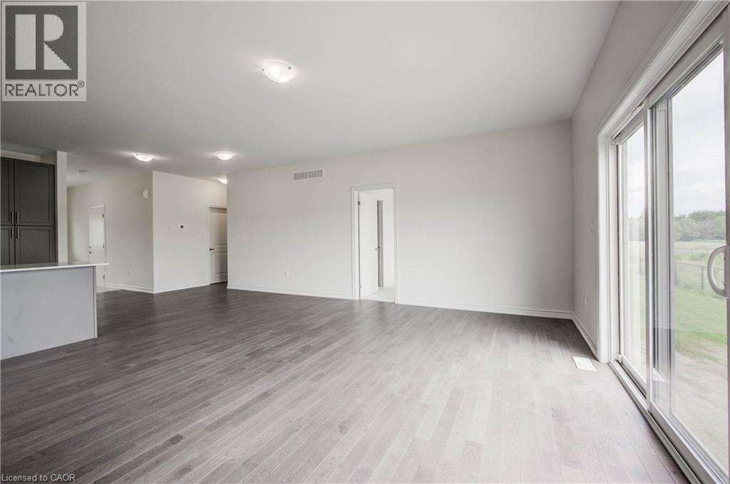 A spacious room with wooden flooring and white walls.