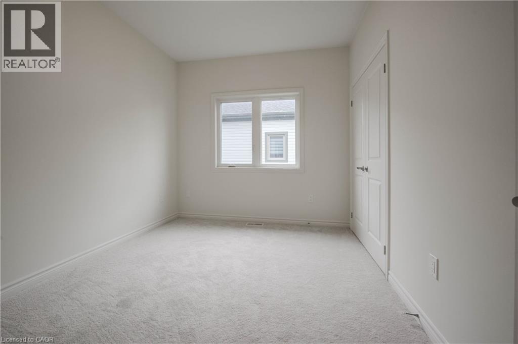 A white bedroom with a window and a door.