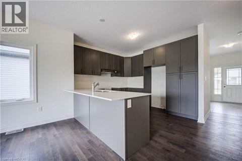A kitchen with dark brown cabinets and a white counter.