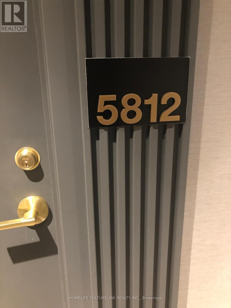 A door with a gold handle and a sign that says 5812.