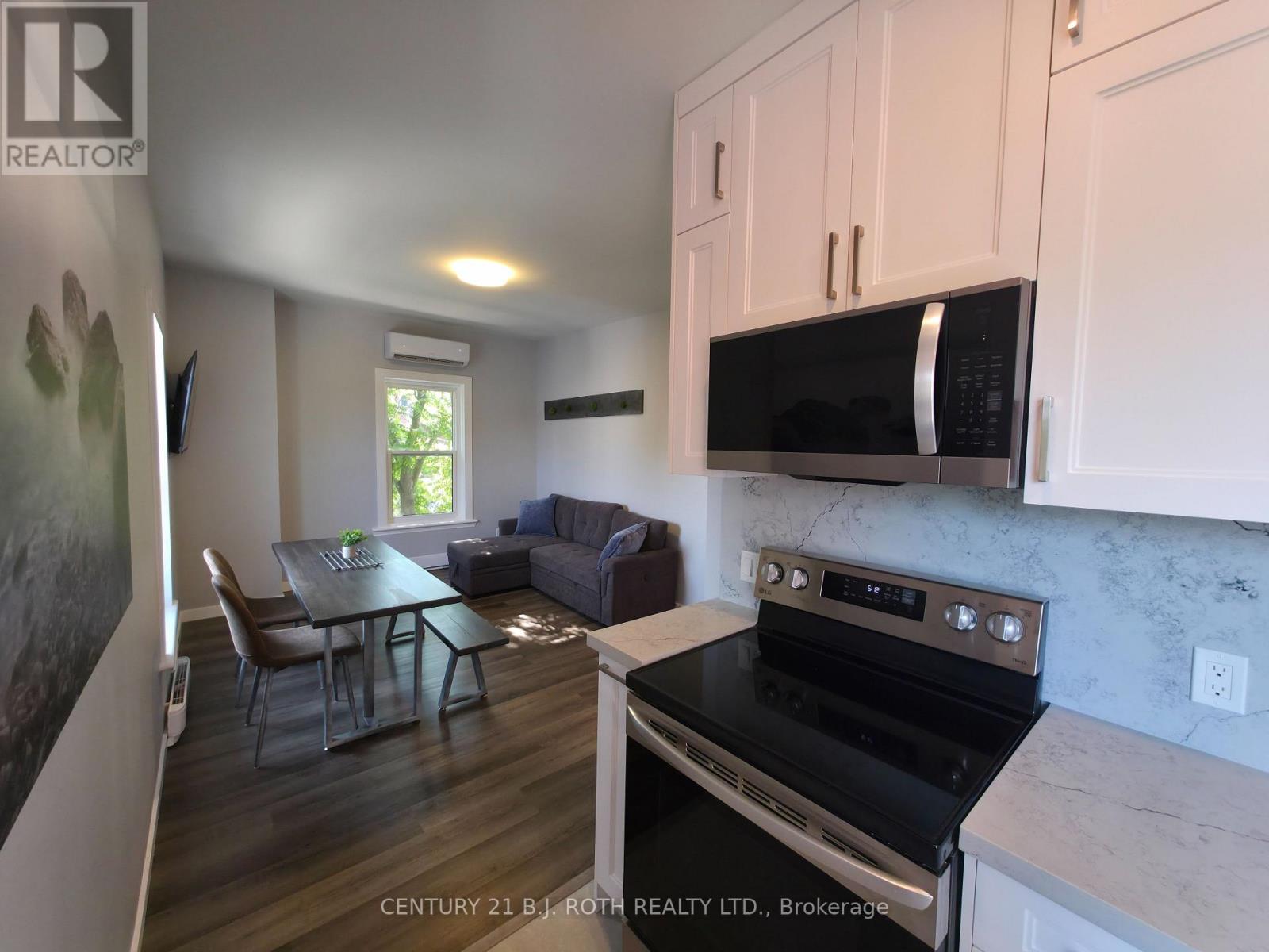 A kitchen with a stove top oven and a microwave above it.