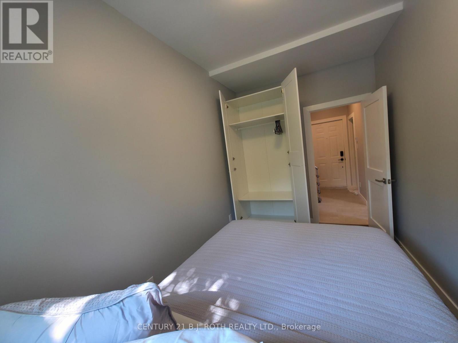 A bedroom with a bed, wardrobe and a doorway leading to another room.