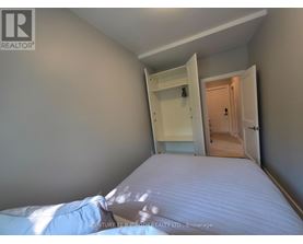 A bedroom with a bed, wardrobe and a doorway leading to another room.