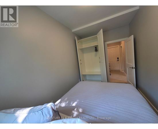 A bedroom with a bed, wardrobe and a doorway leading to another room.
