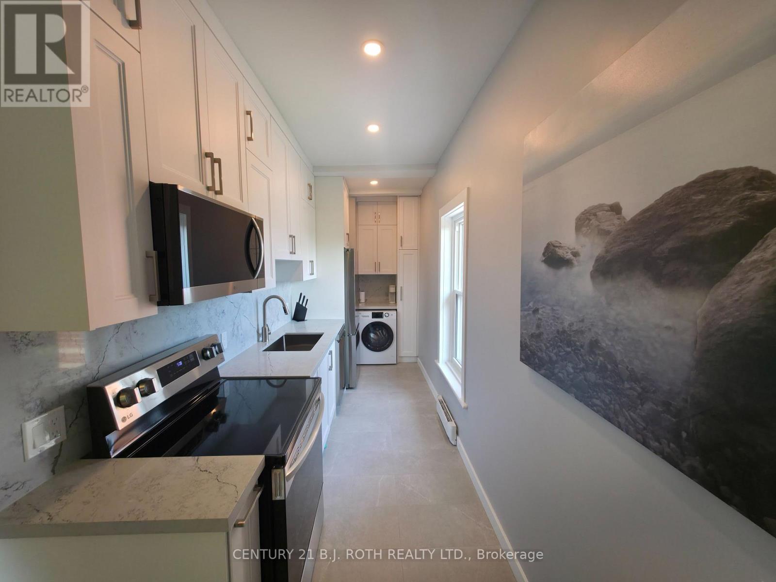 A kitchen with a stove top oven and a microwave on the counter.