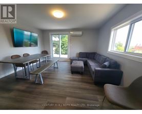 A living room with a couch, table, and chairs.