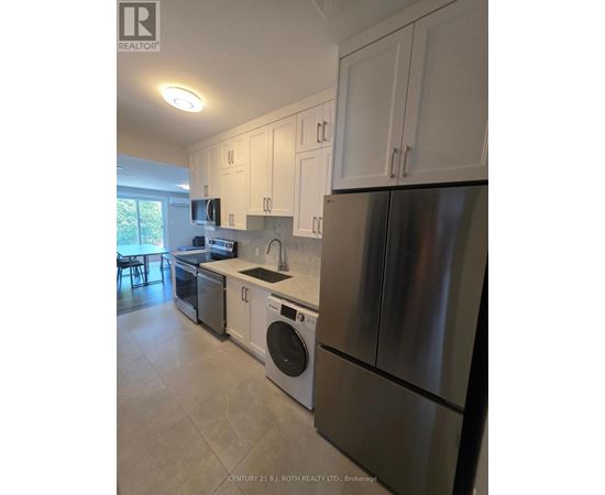 A kitchen with white cabinets and stainless steel appliances.