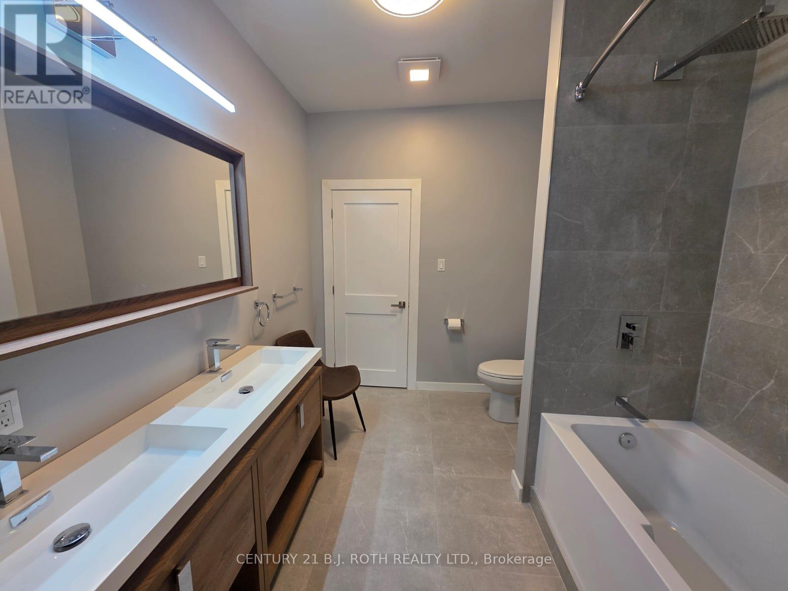 A bathroom with a white tub, sink, and toilet.