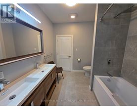 A bathroom with a white tub, sink, and toilet.