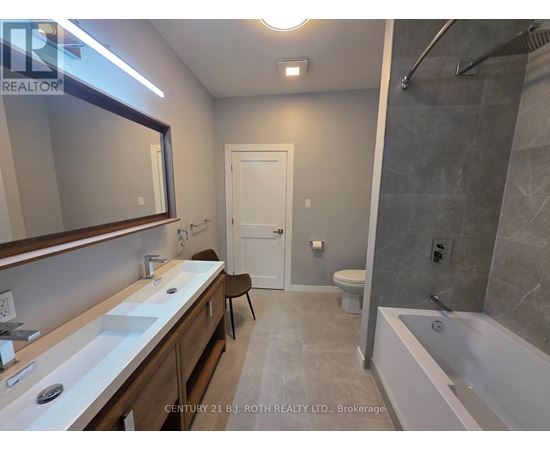 A bathroom with a white tub, sink, and toilet.