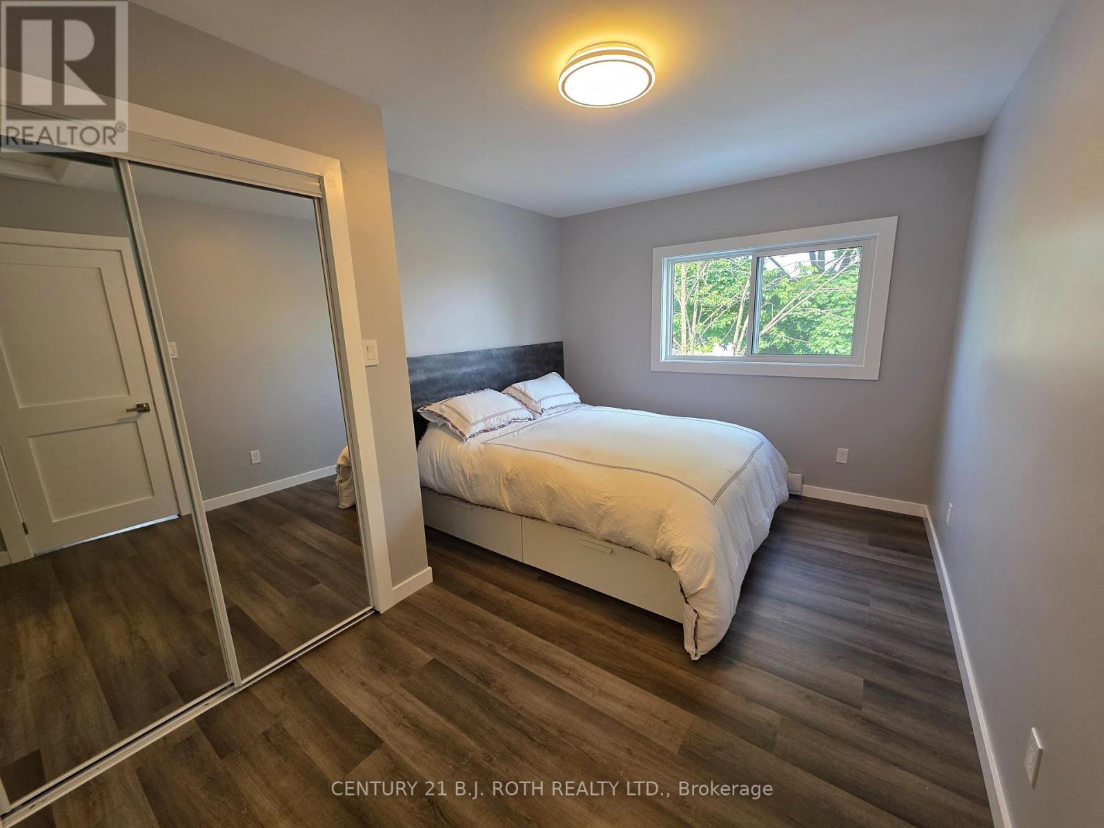 A bedroom with a bed, a window, and a sliding door.