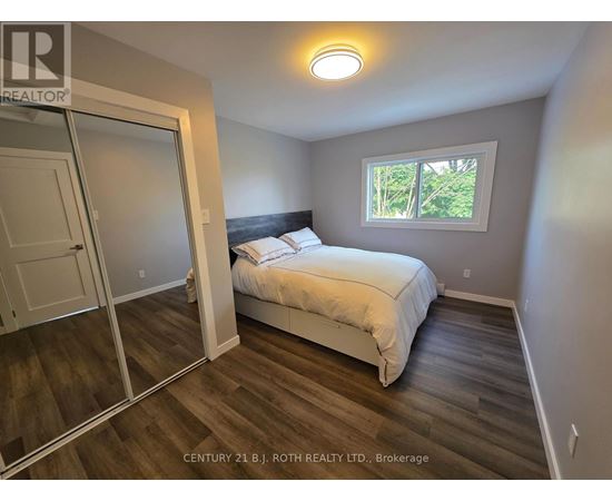A bedroom with a bed, a window, and a sliding door.