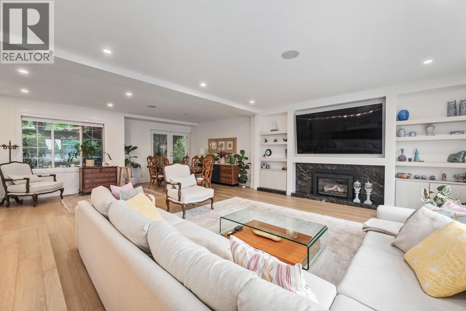 A living room with a white couch and a glass coffee table.