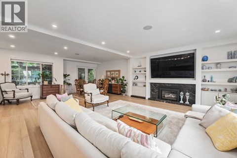 A living room with a white couch and a glass coffee table.