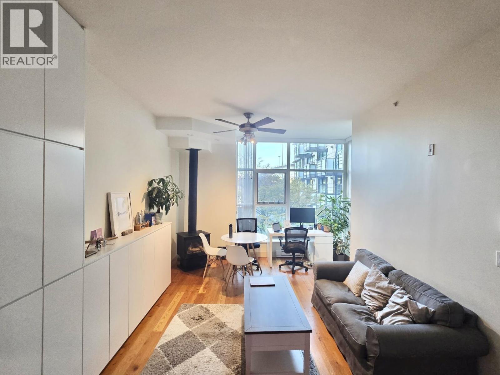 A living room with a couch, a coffee table, and a ceiling fan.