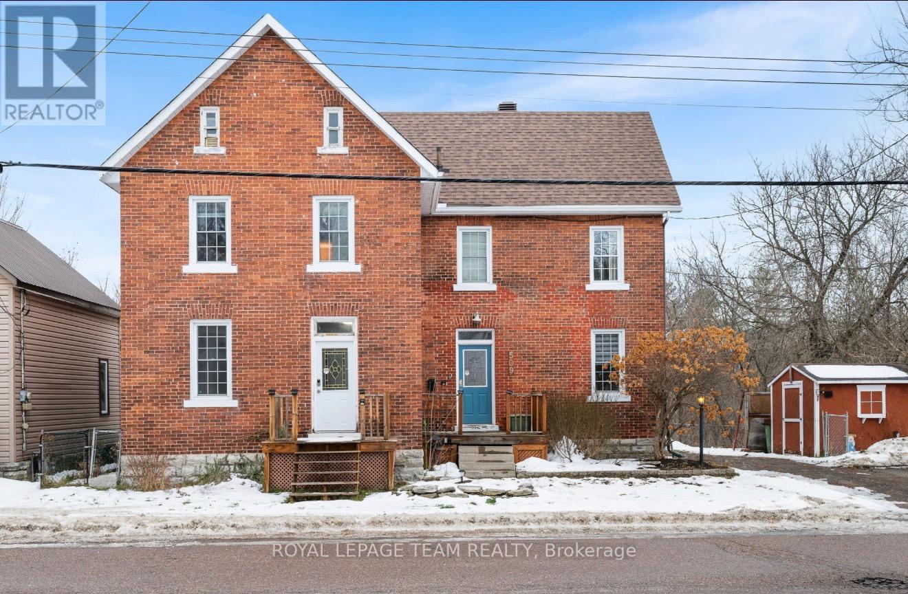 A red brick house with a blue door and windows.