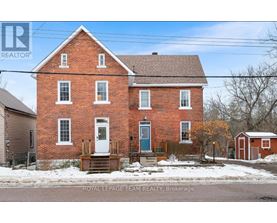 A red brick house with a blue door and windows.