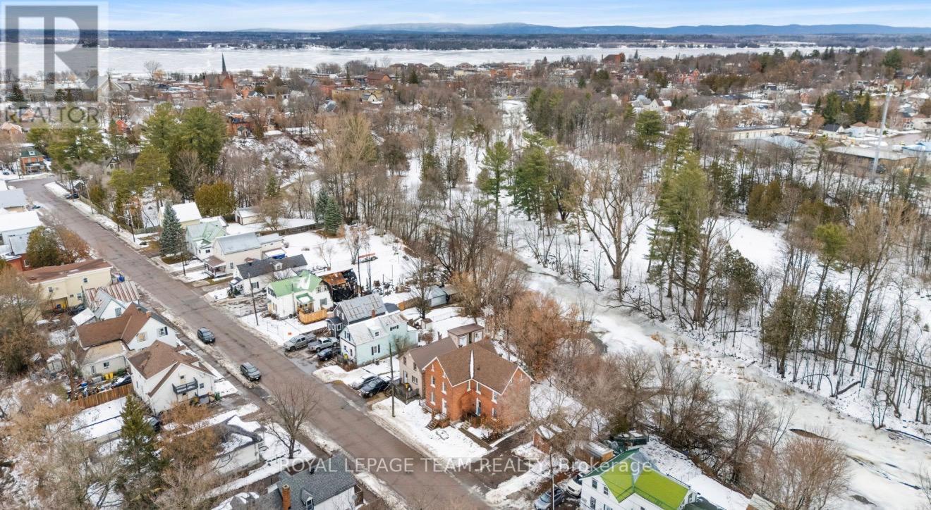 A winter scene of a residential area with houses and trees.