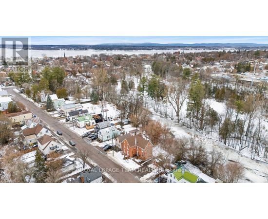 A winter scene of a residential area with houses and trees.