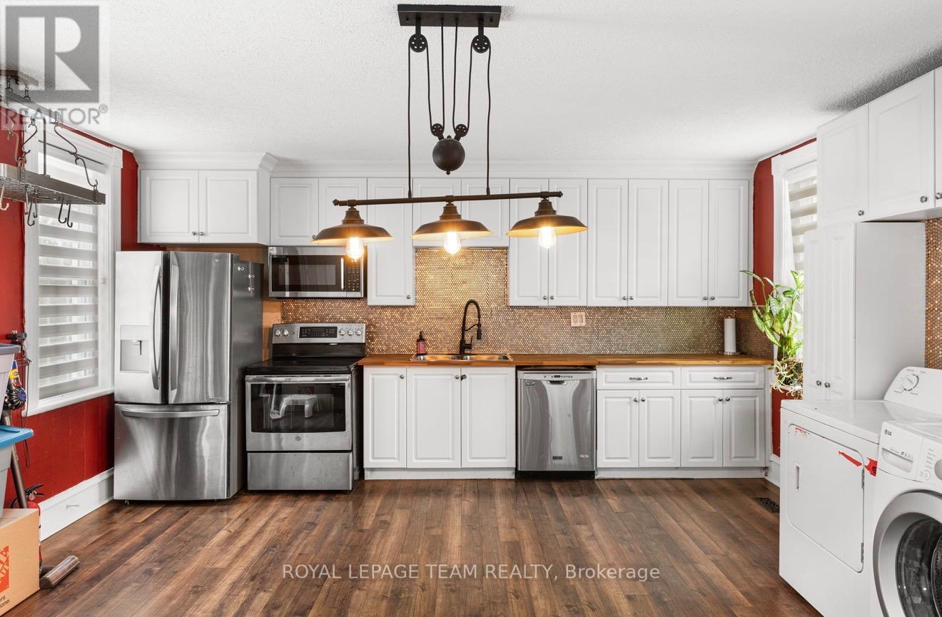 A modern kitchen with white cabinets and a brick backsplash.