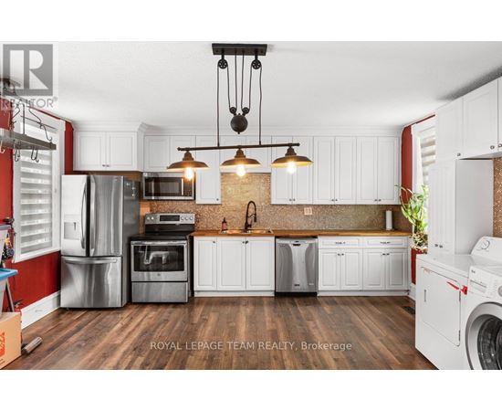 A modern kitchen with white cabinets and a brick backsplash.