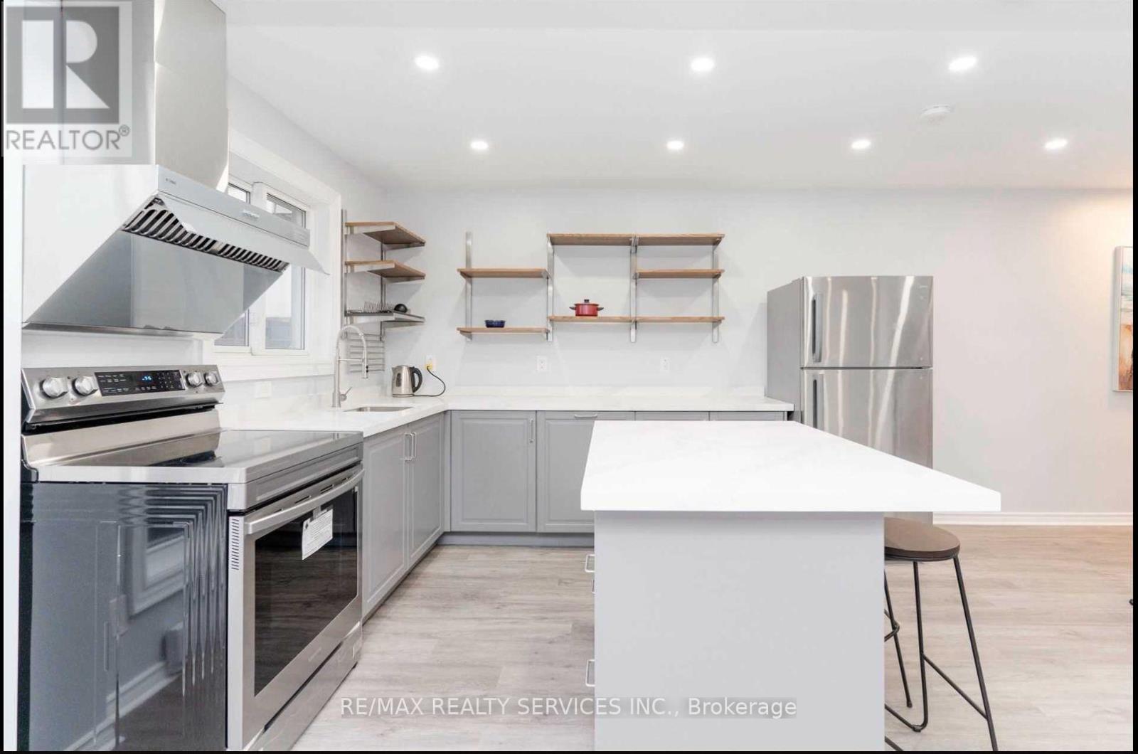 A modern kitchen with a white island and stainless steel appliances.