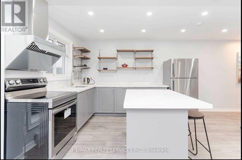 A modern kitchen with a white island and stainless steel appliances.