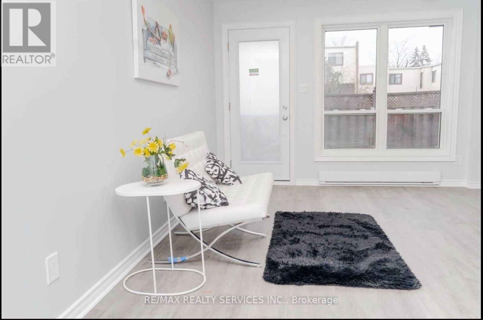 A white chair with a floral arrangement on a table in a room.