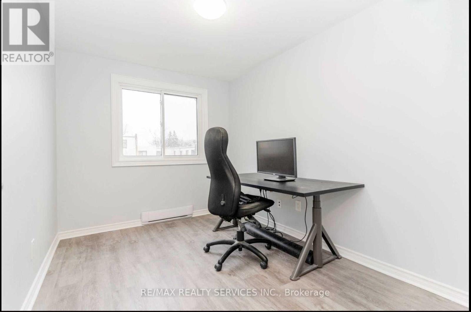 A room with a desk and a computer chair.