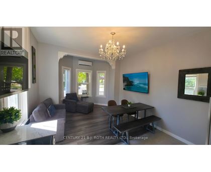 A living room with a grey couch, a black table, and a chandelier.