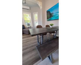 A dining room with a wooden table and chairs.