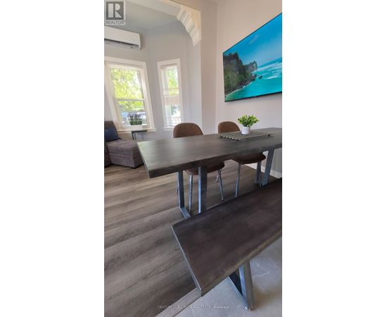 A dining room with a wooden table and chairs.