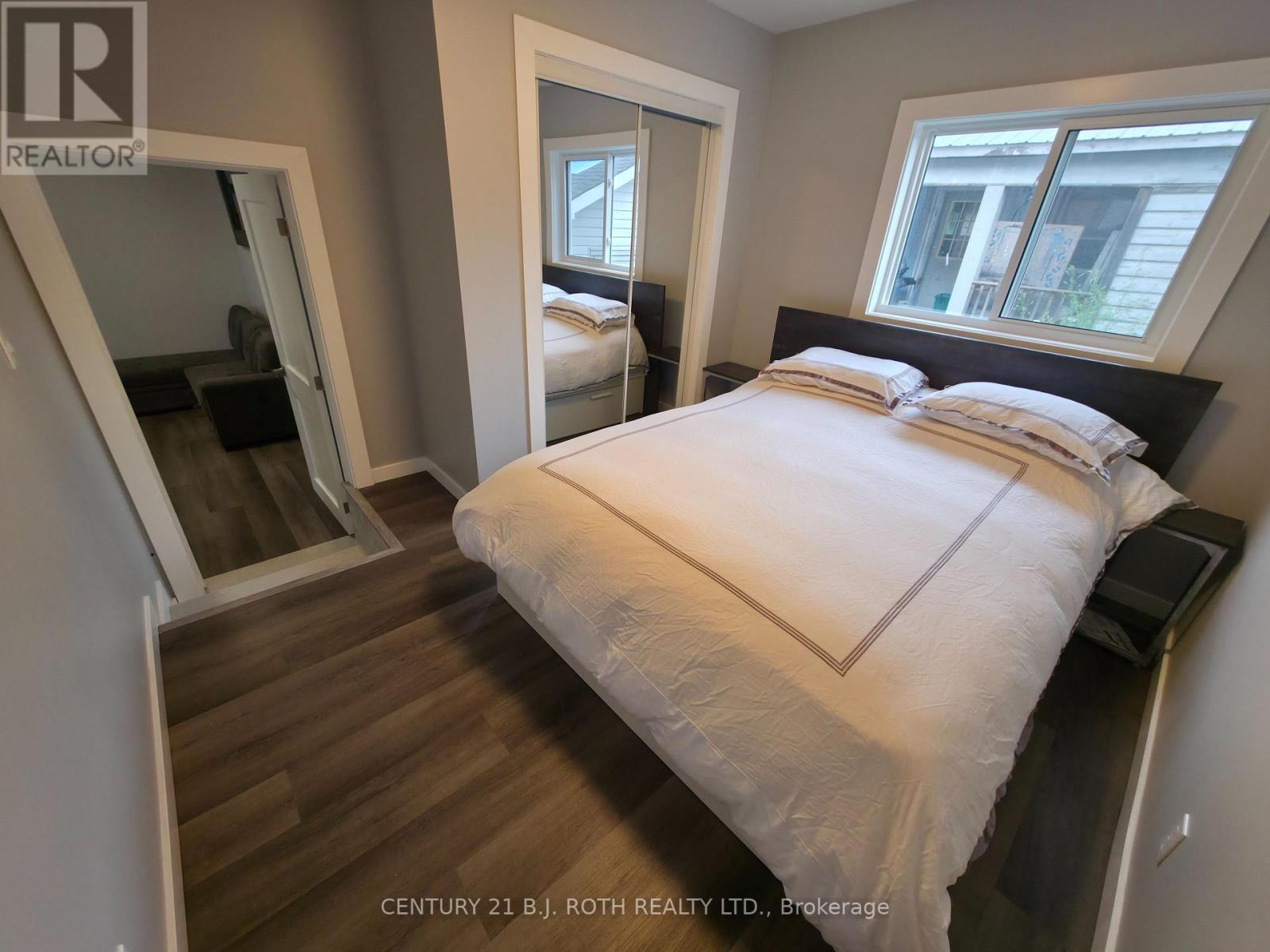 A bedroom with a large bed and a mirror on the wall.