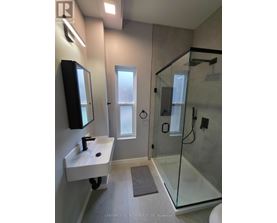 A bathroom with a sink, mirror, and shower.