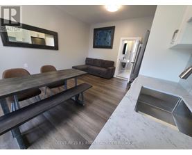 A dining room with a wooden table and chairs.