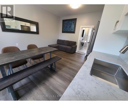 A dining room with a wooden table and chairs.